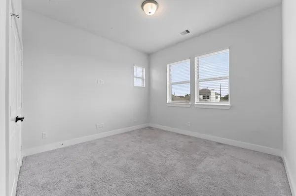 an empty room with windows and closet