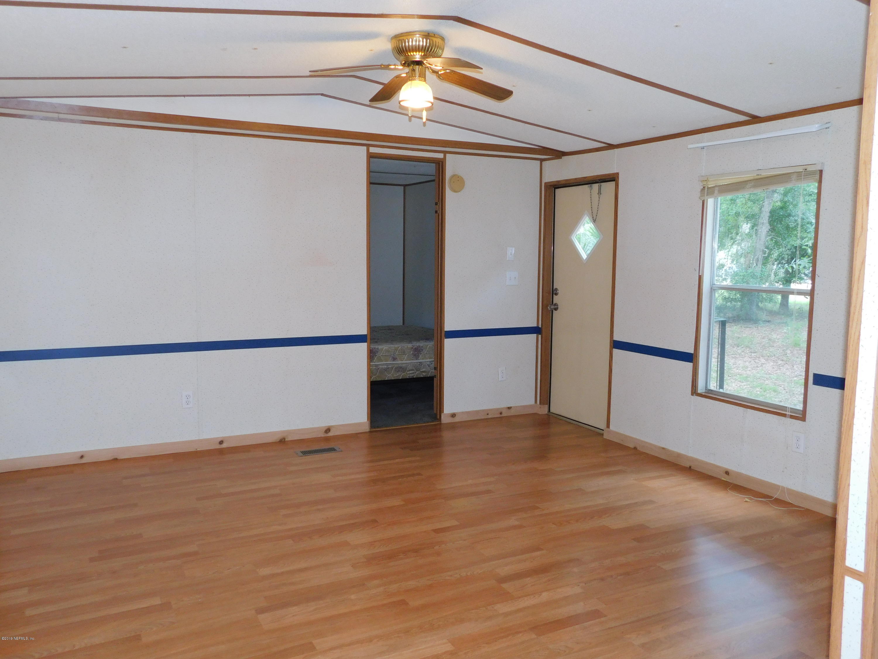 112 Cindy Street Interlachen, FL 32148 - Photo 16 of 33 a view of empty room with wooden floor and fan