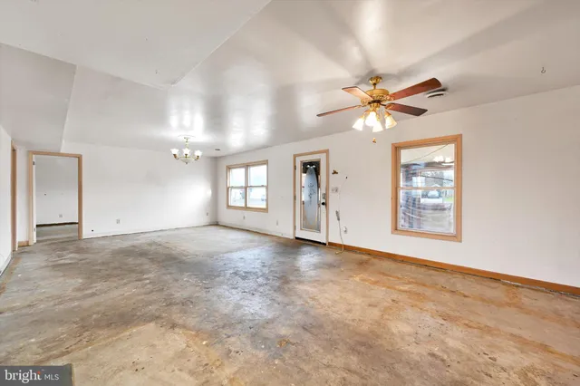 a view of a room with a chandelier fan and windows