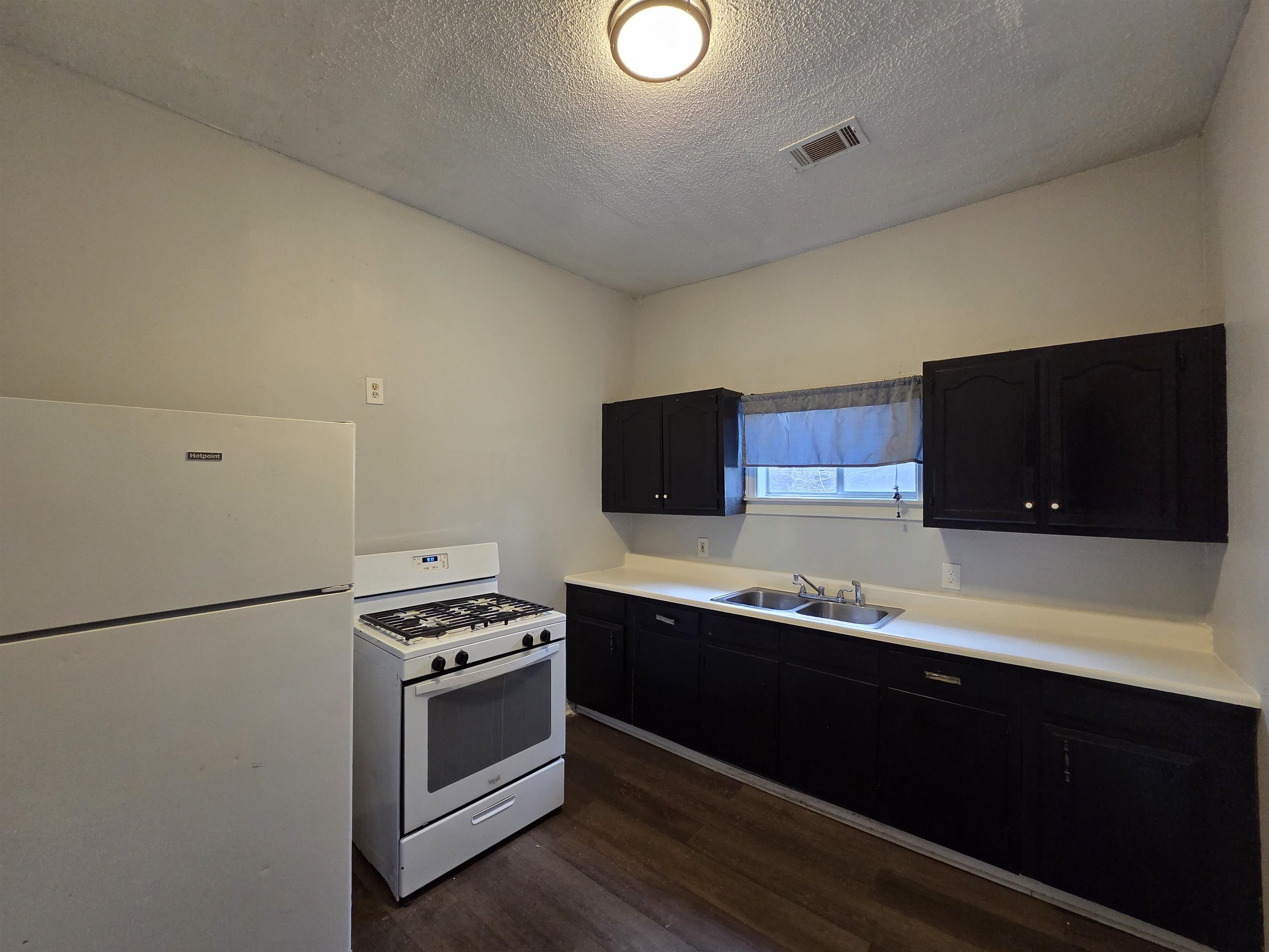 993 Oakview Street, Unit 201 Memphis, TN 38114 - Photo 14 of 16 a kitchen with stainless steel appliances a stove a microwave and white cabinets