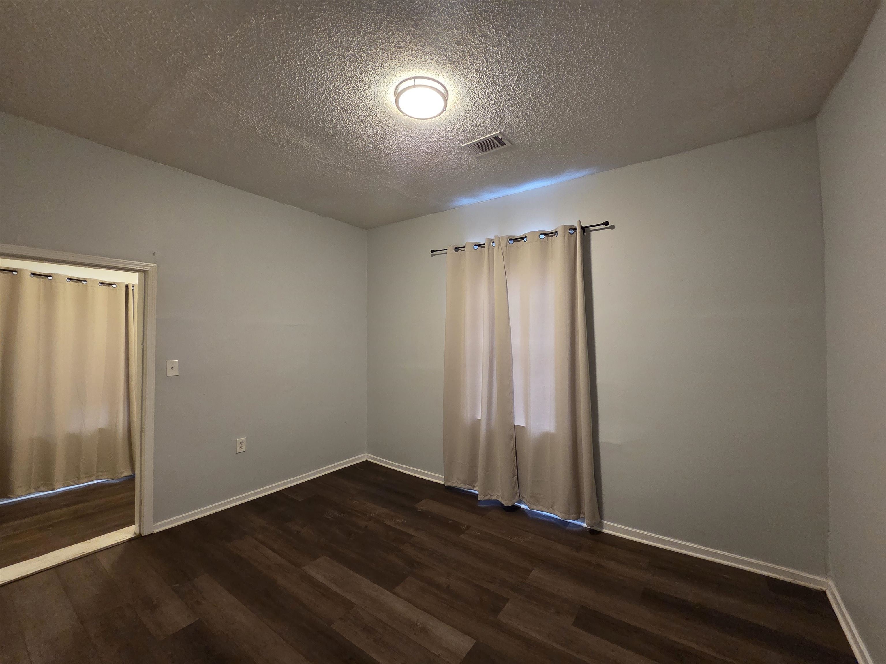 993 Oakview Street, Unit 201 Memphis, TN 38114 - Photo 10 of 16 an empty room with wooden floor and windows