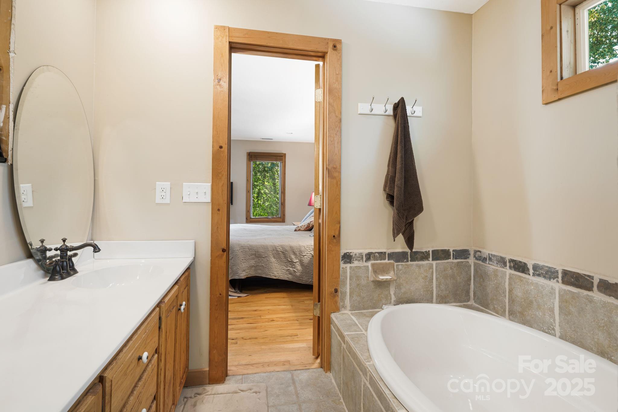 609 Maple Street Brevard, NC 28712 - Photo 10 of 28 a en suite bathroom with a tub sink and mirror