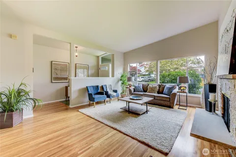a living room with furniture fireplace and a large window