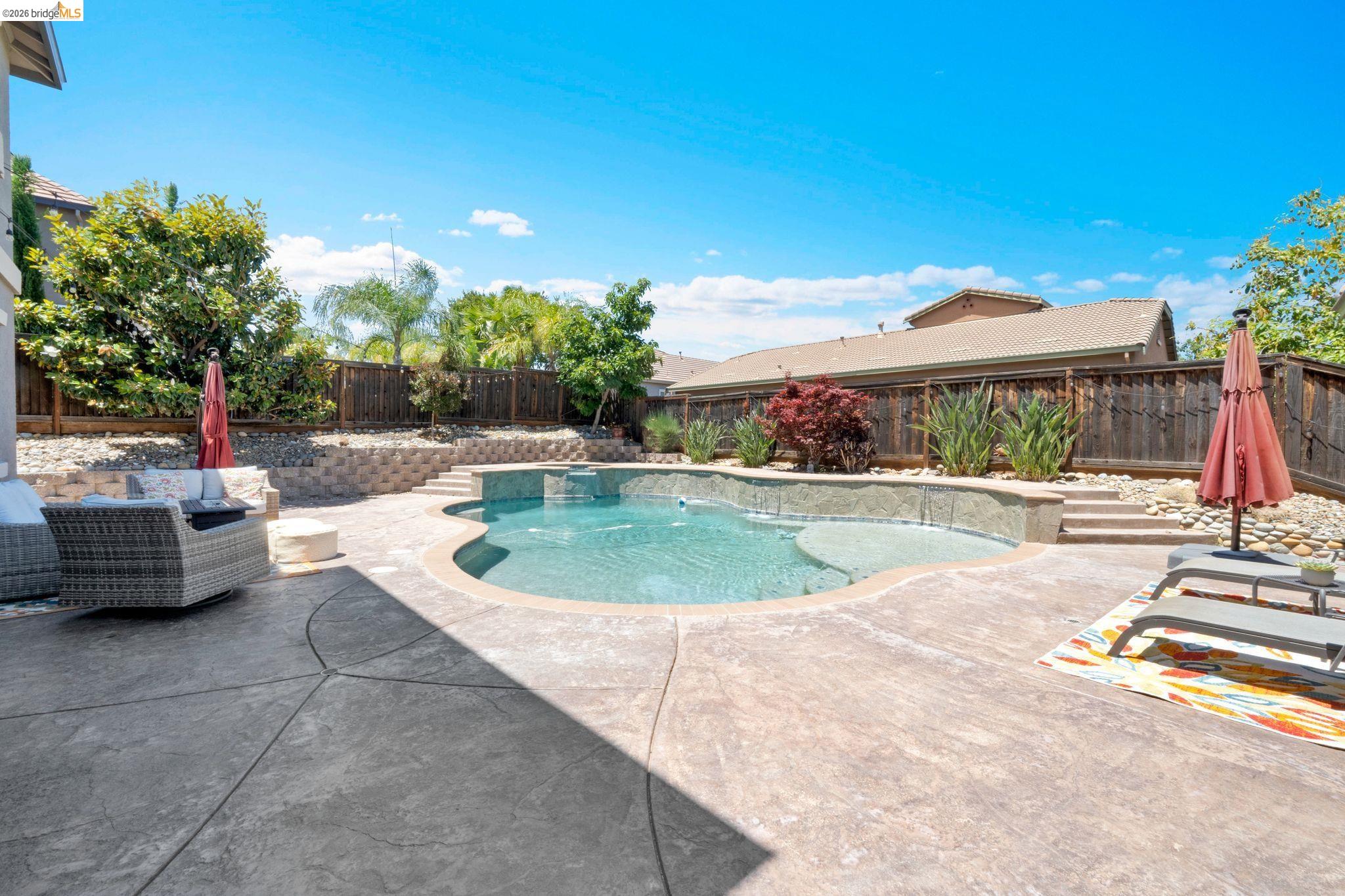 2513 Winged Foot Road Brentwood, CA 94513 - Photo 32 of 45 In-ground swimming pool with an integrated spa, surrounded by textured concrete patio areas