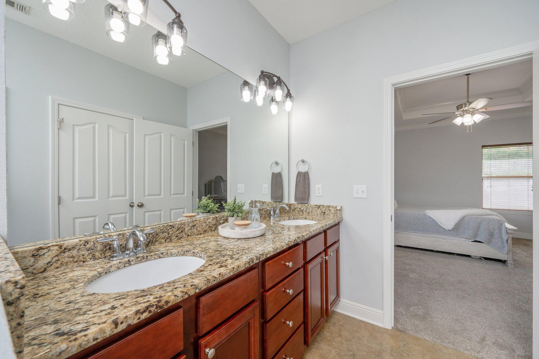 661 Red Fern Road Crestview, FL 32536 - Photo 20 of 28 a bathroom with a granite countertop double vanity sink and a mirror