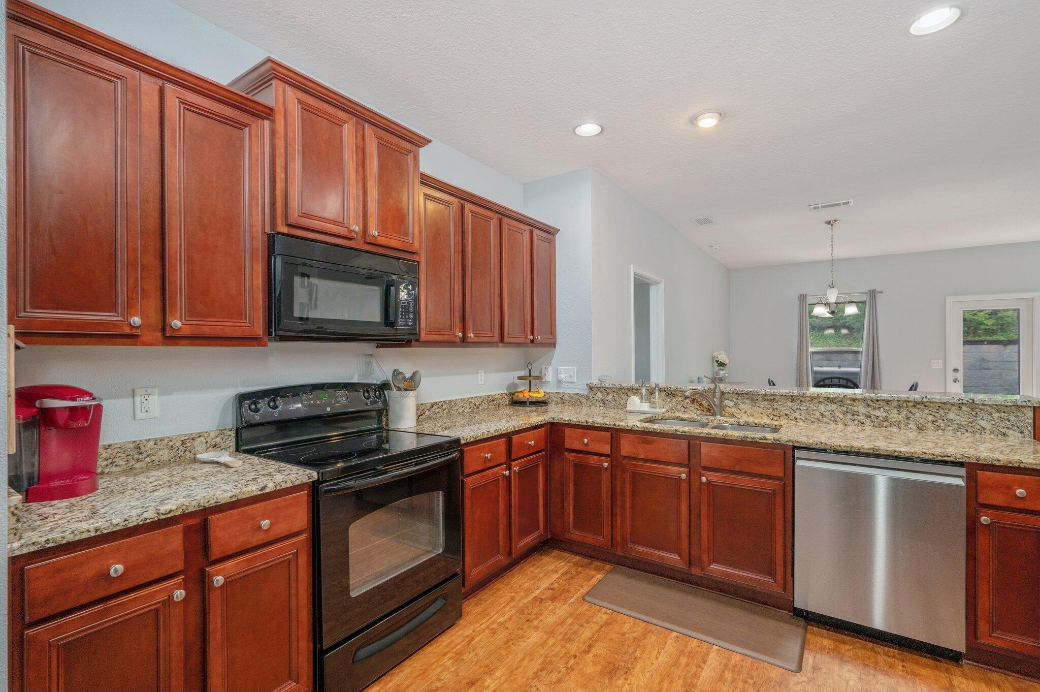 661 Red Fern Road Crestview, FL 32536 - Photo 7 of 28 a kitchen with stainless steel appliances granite countertop wooden cabinets stove top oven and granite counter top