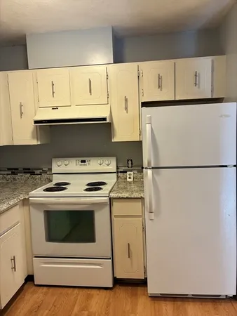 a kitchen with white cabinets and white appliances