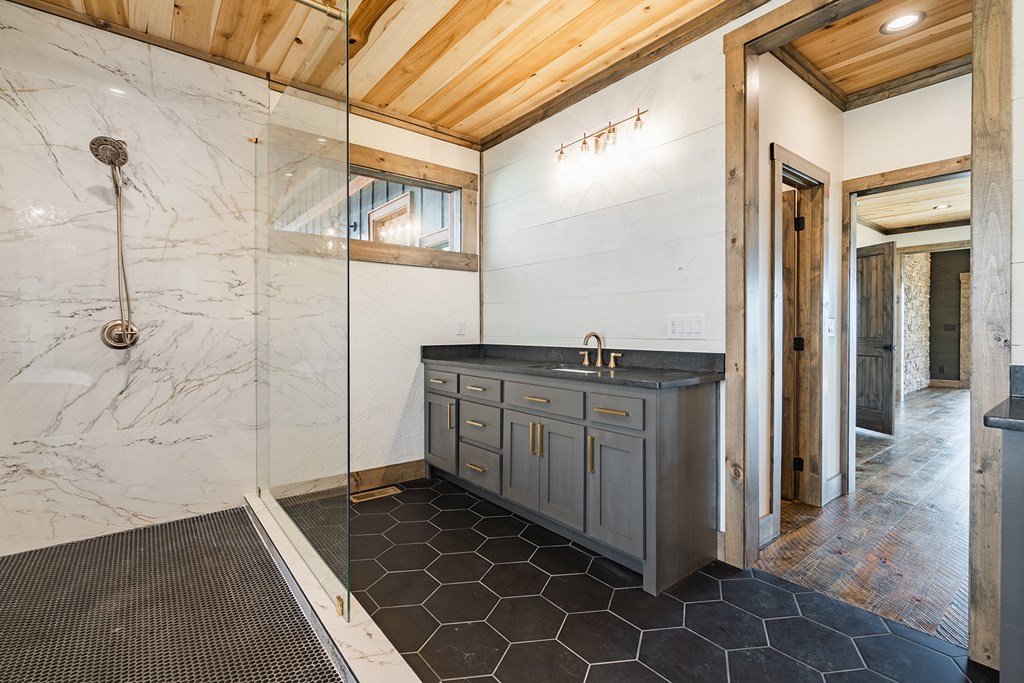 925 Heards Ridge Morganton, GA 30560 - Photo 30 of 70 a bathroom with a granite countertop sink a mirror and shower