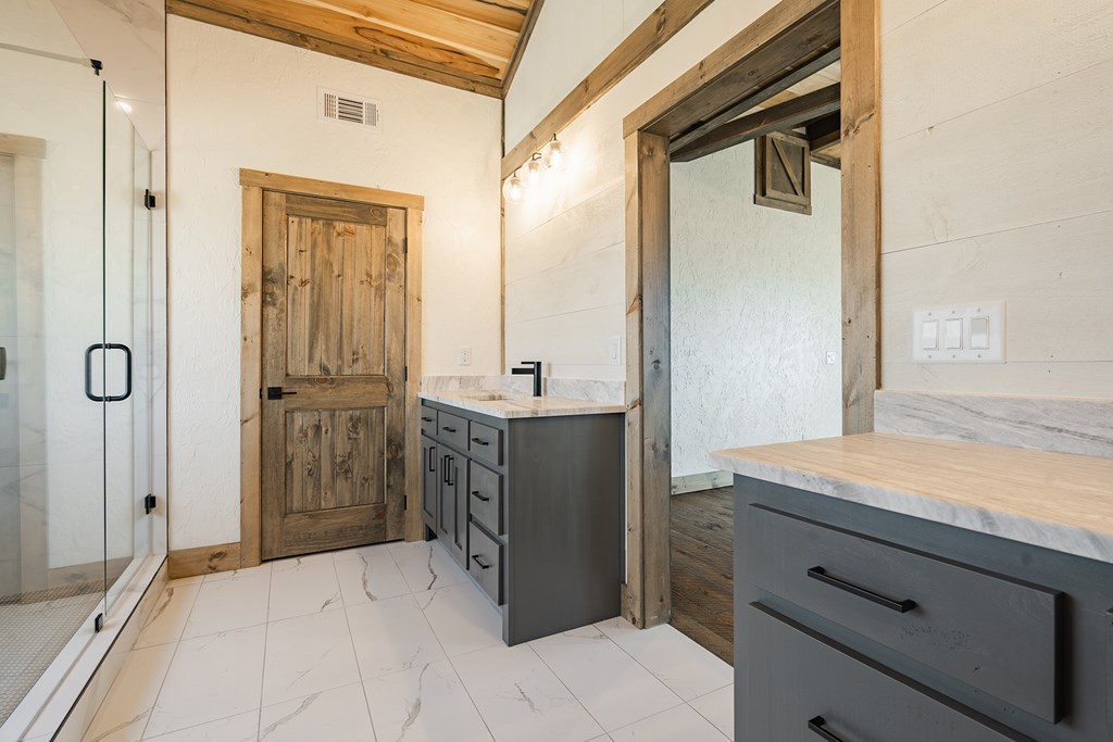 925 Heards Ridge Morganton, GA 30560 - Photo 44 of 70 a bathroom with a granite countertop sink a mirror and a shower