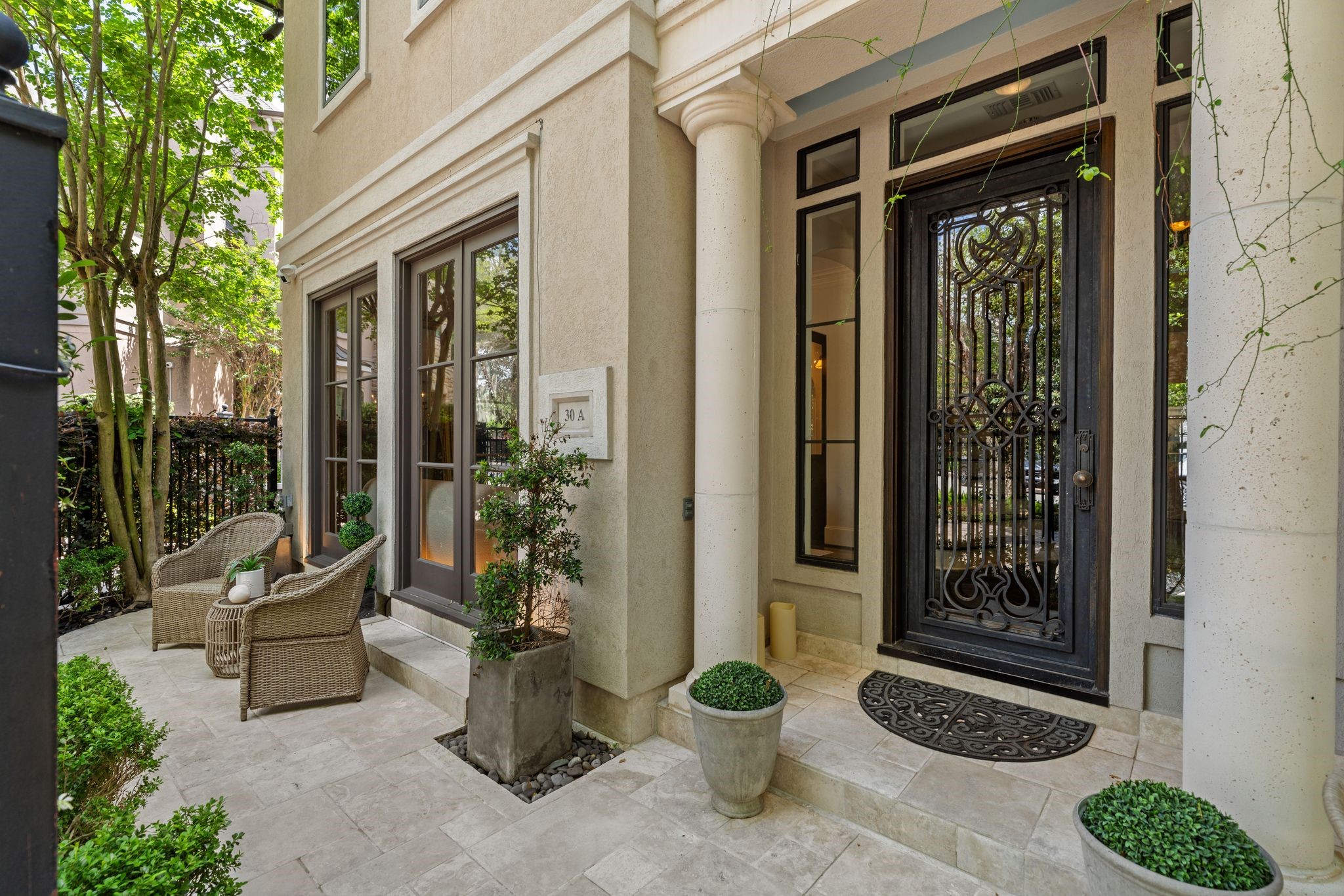 30 Hackberry Lane, Unit A Houston, TX 77027 - Photo 4 of 42 Charming gated garden-home entry with covered porch, refined architectural columns, and inviting exterior seating area.