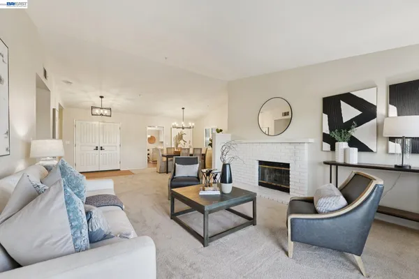 a living room with furniture a rug a fireplace and a large window