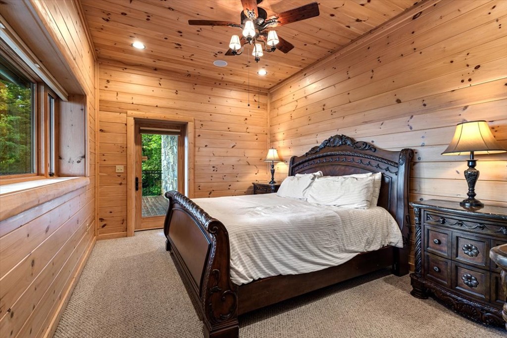 373 Rising Star Lane Mineral Bluff, GA 30559 - Photo 88 of 98 a bedroom with a large bed and a chandelier