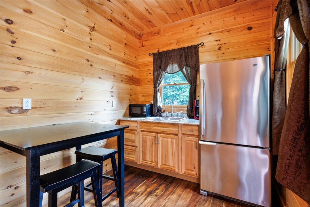 373 Rising Star Lane Mineral Bluff, GA 30559 - Photo 96 of 98 a kitchen with stainless steel appliances a refrigerator a sink a stove and white cabinets with wooden floor