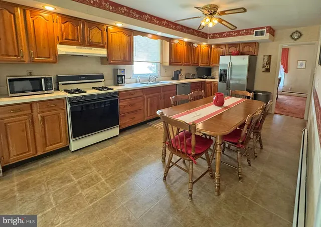 a kitchen with a sink a stove and chairs