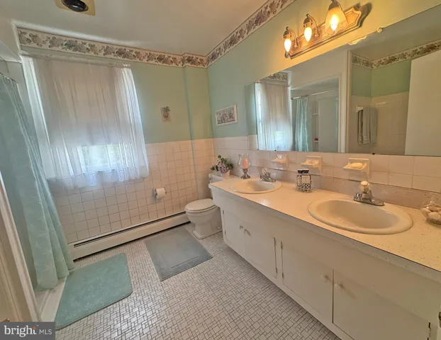 a spacious bathroom with a toilet a sink and mirror