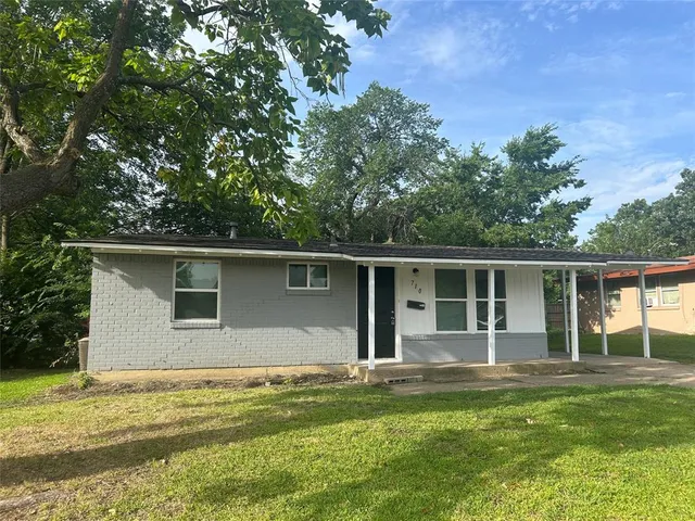 a backyard of a house with table and chairs