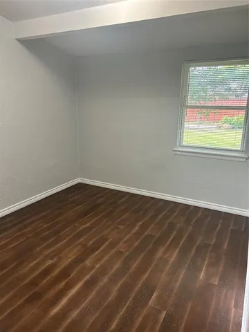 a view of a room with wooden floor and window