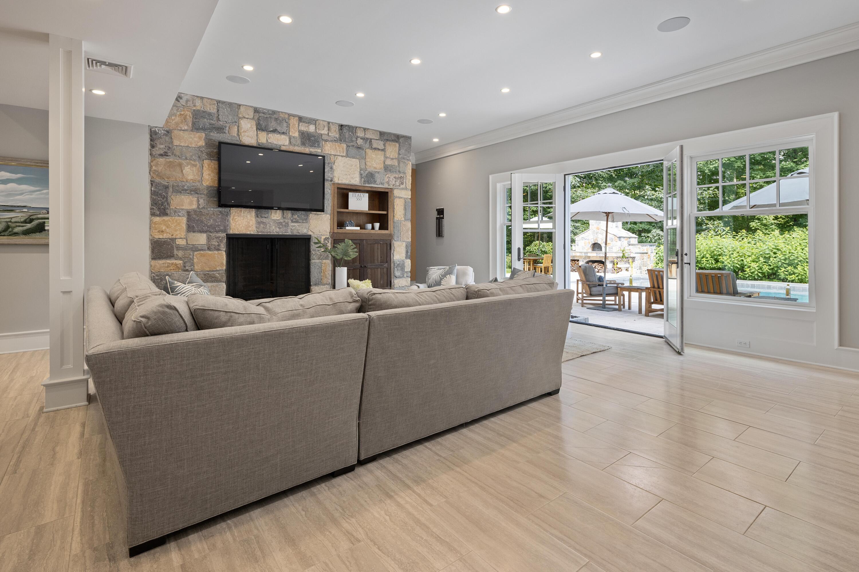 163 Chichester Road New Canaan, CT 06840 - Photo 27 of 40 a living room with furniture a fireplace and a flat screen tv
