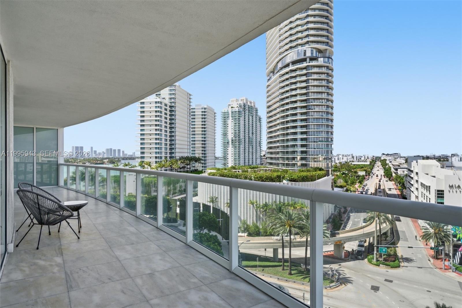 450 Alton Road, Unit 910 Miami Beach, FL 33139 - Photo 32 of 59 a view of a balcony with two chairs and a wooden fence