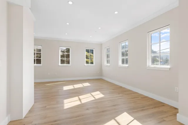a kitchen with cabinets stainless steel appliances and wooden floor
