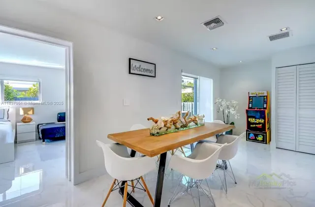 a dining room with furniture and kitchen view