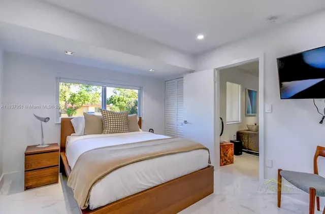 a bedroom with a large bed and a chandelier