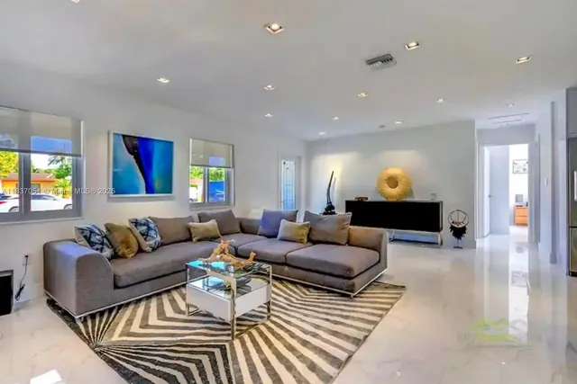 a living room with furniture and a wooden floor