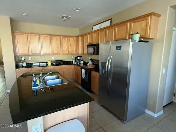 a kitchen with stainless steel appliances granite countertop a refrigerator a sink a stove and island