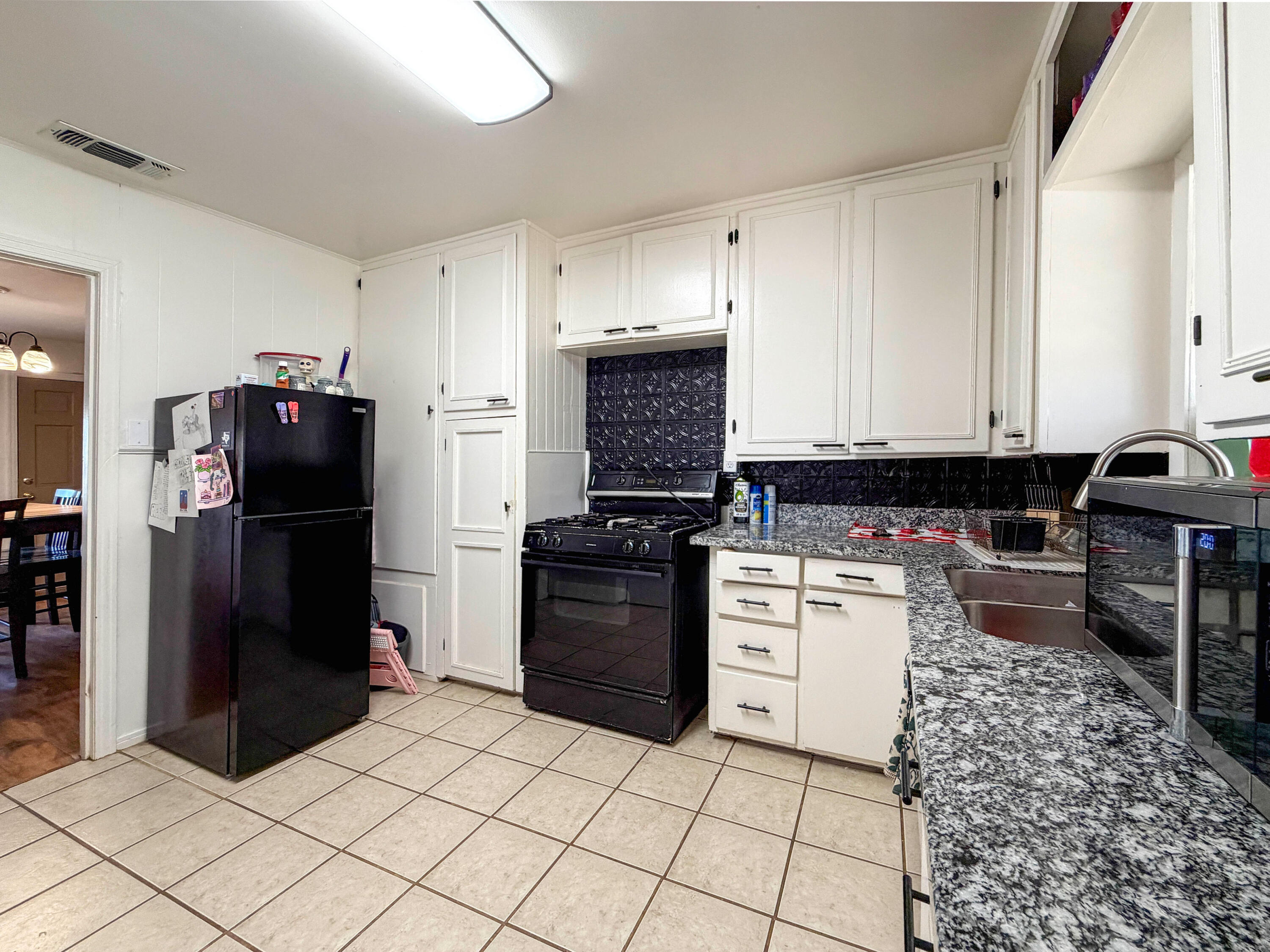 3221 Emory Street Lubbock, TX 79415 - Photo 11 of 15 a kitchen with a refrigerator stove and cabinets