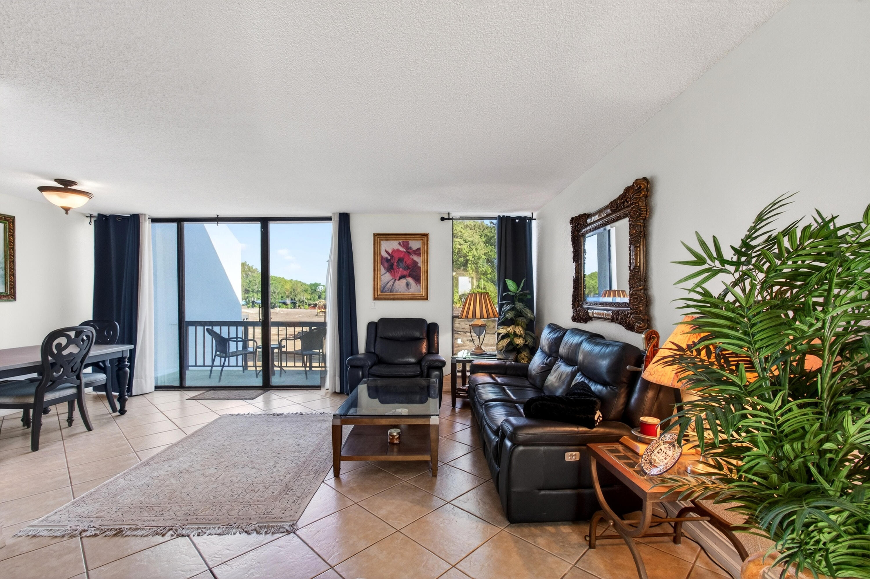 2303 Bridgewood Drive, Unit 2303 Boca Raton, FL 33434 - Photo 7 of 45 a living room with furniture a floor to ceiling window and a flat screen tv