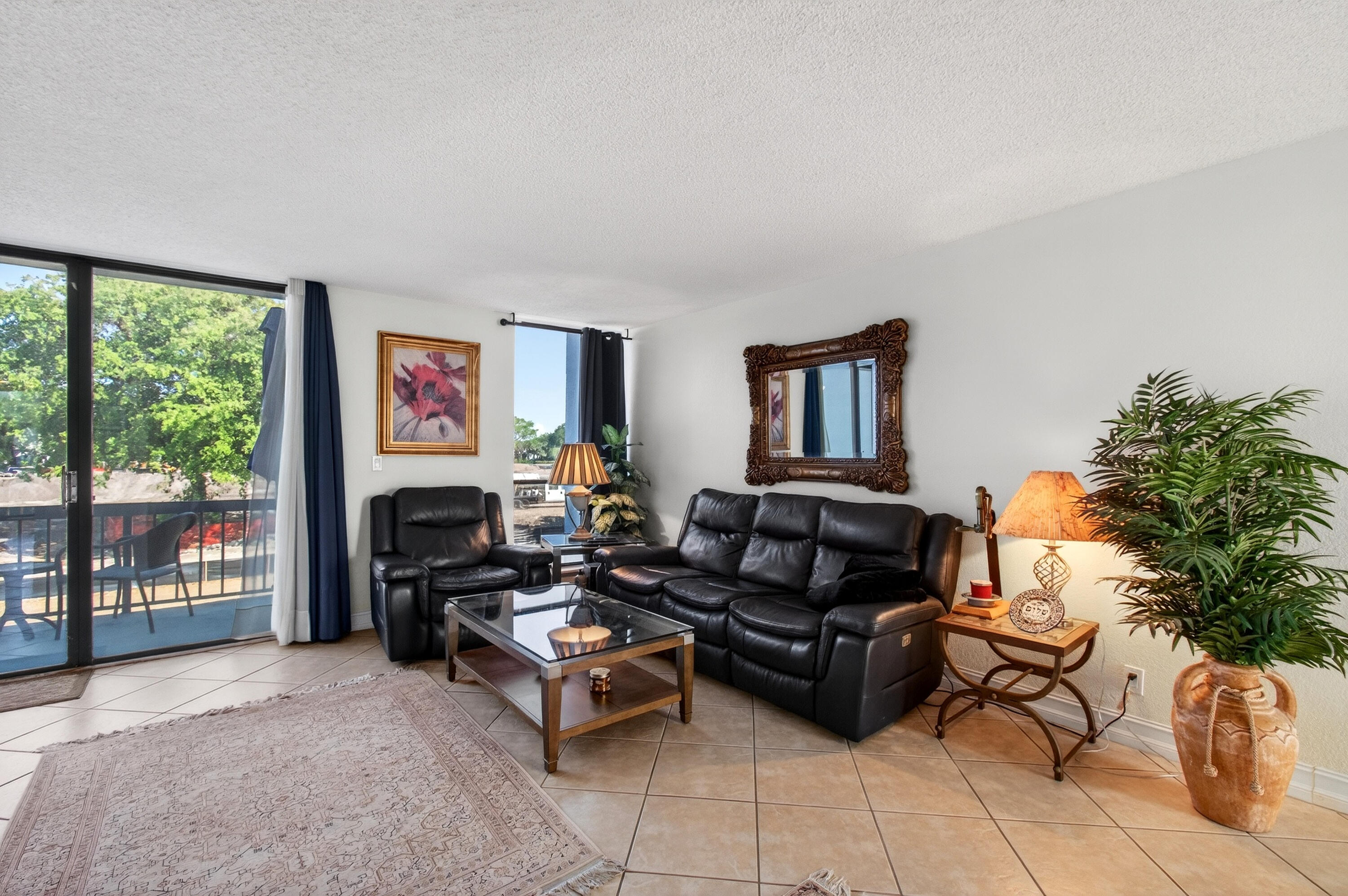 2303 Bridgewood Drive, Unit 2303 Boca Raton, FL 33434 - Photo 8 of 45 a living room with furniture a flat screen tv and a floor to ceiling window