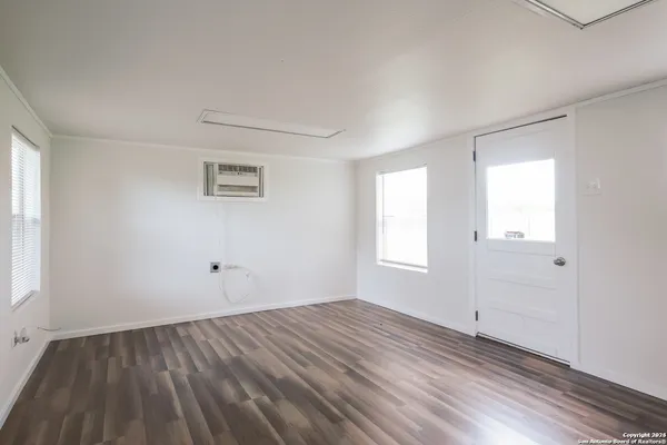 wooden floor in an empty room with a window