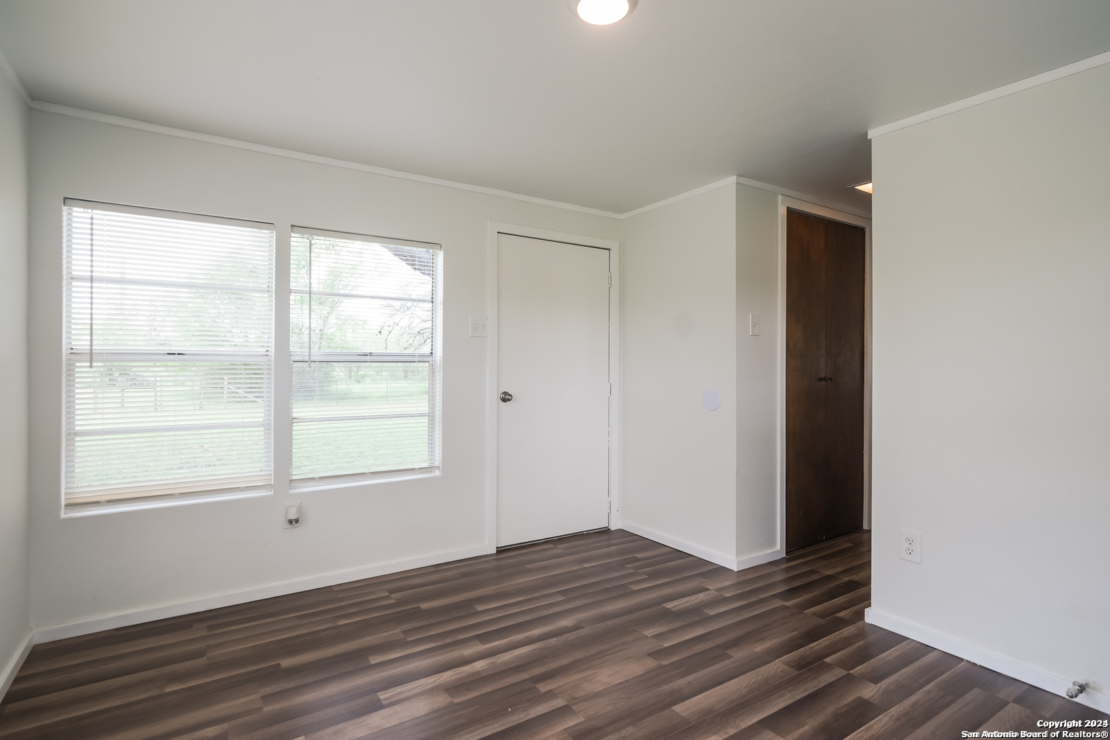 5515 Farm To Market 462 Devine, TX 78016 - Photo 15 of 27 an empty room with wooden floor and windows