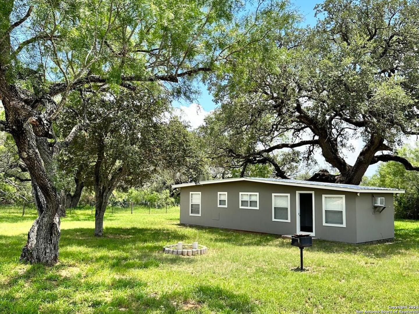 5515 Farm To Market 462 Devine, TX 78016 - Photo 3 of 27 a house that has a tree in front of a yard