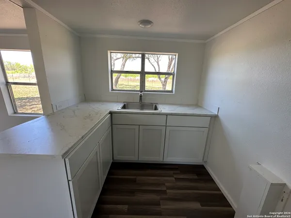 a utility room with wooden cabinets and a window