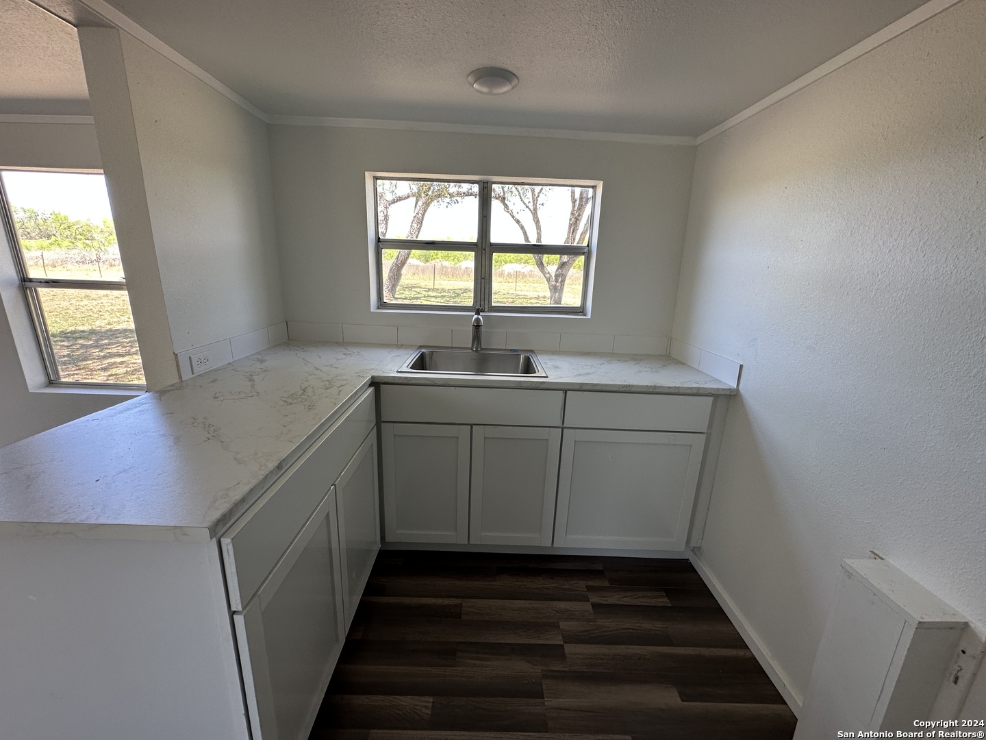 5515 Farm To Market 462 Devine, TX 78016 - Photo 9 of 27 a utility room with wooden cabinets and a window