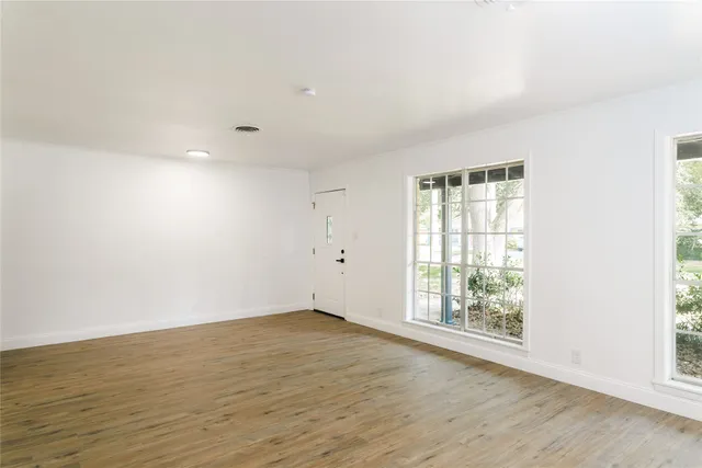 a large kitchen with stainless steel appliances granite countertop a stove a sink dishwasher and a refrigerator with wooden floor