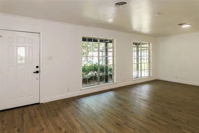 a view of a room with wooden floor and window