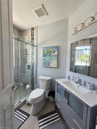 a spacious bathroom with a double vanity sink toilet mirror and shower