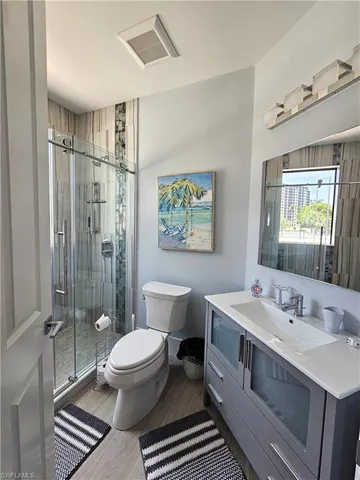 a spacious bathroom with a double vanity sink toilet mirror and shower