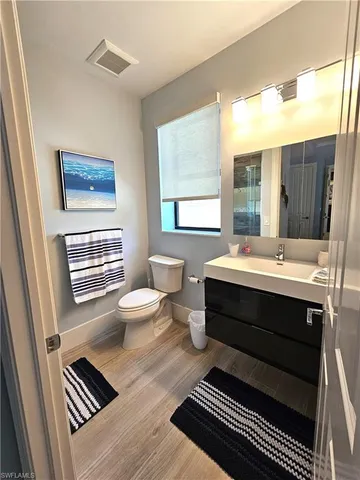 a bathroom with a sink a toilet and a window