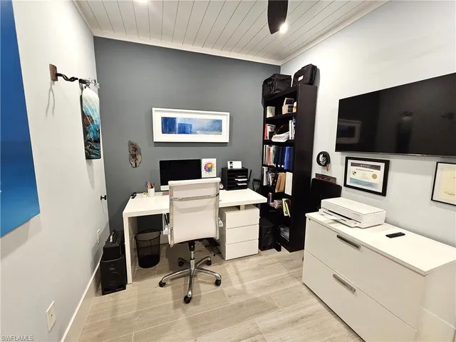 a work place with a flat screen tv and gym equipment