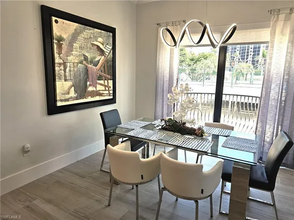 a view of a dining room with furniture a chandelier and wooden floor