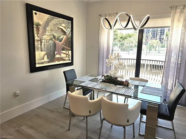 a view of a dining room with furniture a chandelier and wooden floor