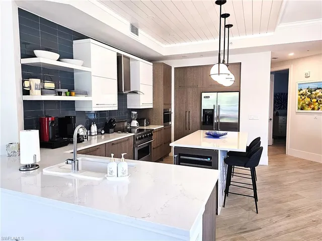 a kitchen with stainless steel appliances granite countertop a sink a stove and a wooden floors