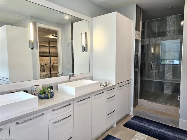 a bathroom with a granite countertop sink a toilet and shower