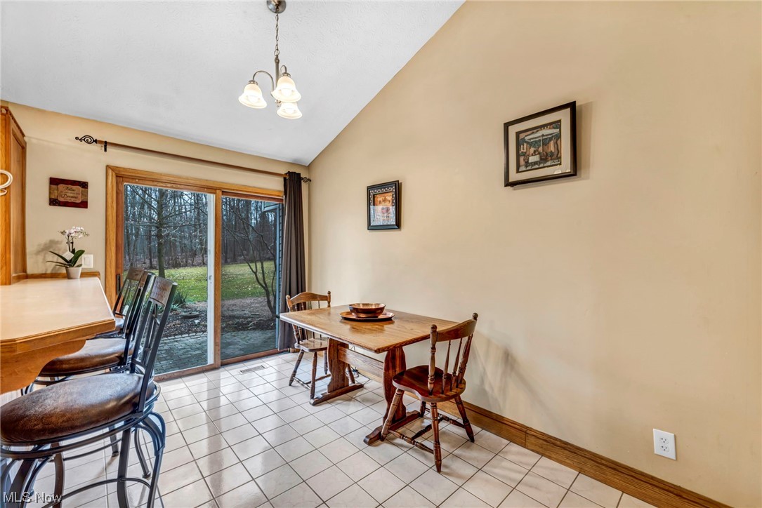 3324 Poe Road Medina, OH 44256 - Photo 7 of 26 Dining space featuring a notable chandelier, light tile floors, and high vaulted ceiling