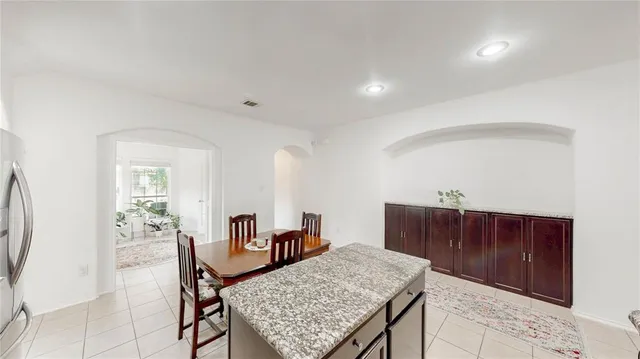 a view of kitchen with refrigerator a dining table and chairs