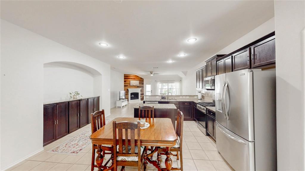 1808 Dr Sanders Road Providence Village, TX 76227 - Photo 12 of 31 a view of kitchen with refrigerator a dining table and chairs