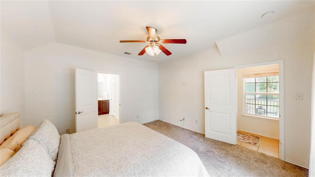 1808 Dr Sanders Road Providence Village, TX 76227 - Photo 14 of 31 a bedroom with a bed and a chandelier